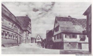 Dorfmitte am Kronenbüggele mit Gasthaus "Krone", Kelter und den Gebäuden Hartmann, alte Schule und Schäfer auf einer 1940 versandten Postkarte (Stadtarchiv Mühlacker)